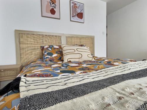 1 dormitorio con cama con edredón y almohadas en Le vercors, en Chabeuil