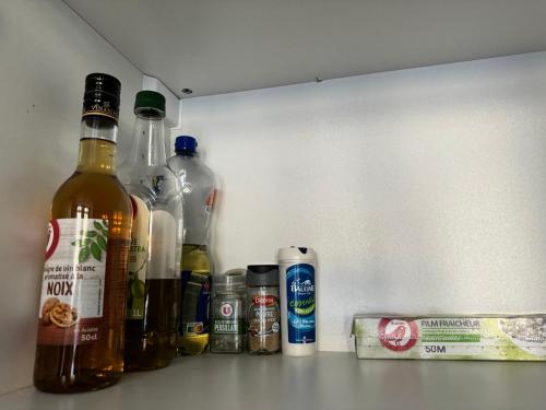 a group of bottles of alcohol sitting on a shelf at Studio en plein cœur de ville in Saint-Omer