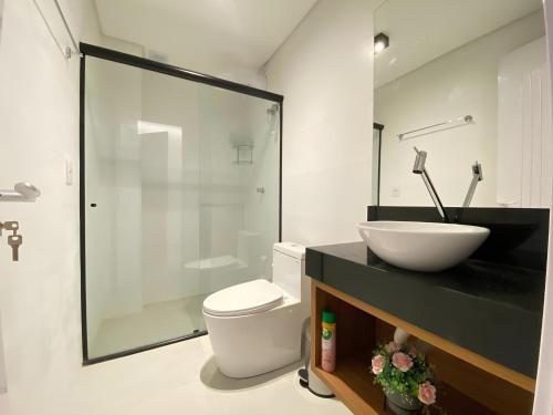 a bathroom with a white toilet and a sink at Flat Home Business 202 Centro Pomerode in Pomerode