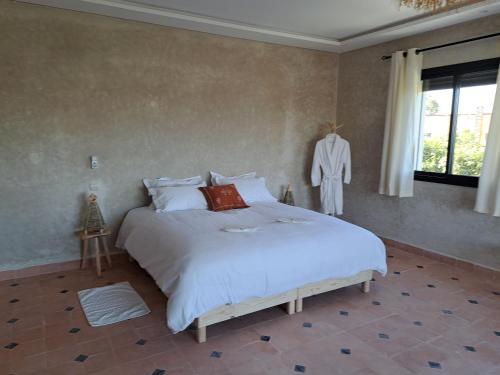 um quarto com uma grande cama branca e uma janela em Villa Rahma em Marrakech