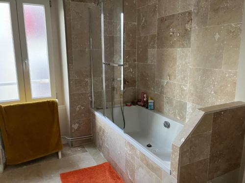 y baño con bañera y ducha. en Chambre d’hôte proche Paris, en Saint-Martin-du-Tertre