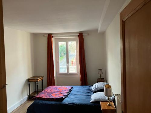 Un dormitorio con una cama azul y una ventana en Chambre d’hôte proche Paris, en Saint-Martin-du-Tertre