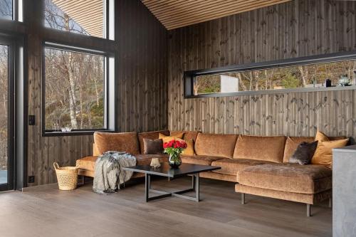 a living room with a couch and a table at Nybygget arkitekt tegnet Snøhetta i vakker natur in Sand