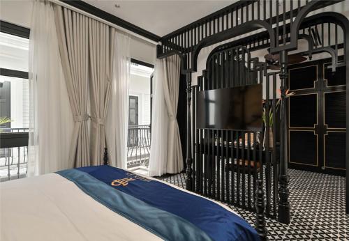 a bedroom with a black bed and a television at Thiên Ân Boutique Hotel in Bạc Liêu