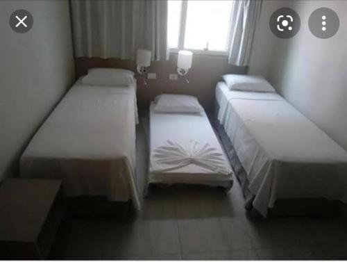 a room with three beds and a window at Salinas Premium resort in Salinópolis