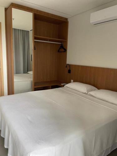 a bedroom with a large white bed and a mirror at Salinas Premium resort in Salinópolis