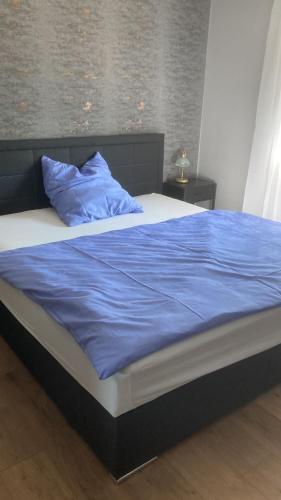 a bed with a blue blanket and pillows on it at Ferienwohnung Christel in Erlenbach am Main