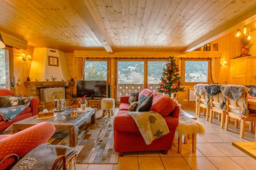 a living room filled with furniture and a christmas tree at Luxury Family Ski Chalet - Jacuzzi BBQ - Near Lake Golf - Multipass access 60 Summer activities - Sleep 10 in Les Gets