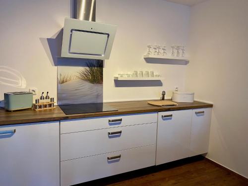 a kitchen with white cabinets and a sink at Ferienwohnung Kilz in Gensingen an der Nahe in Gensingen