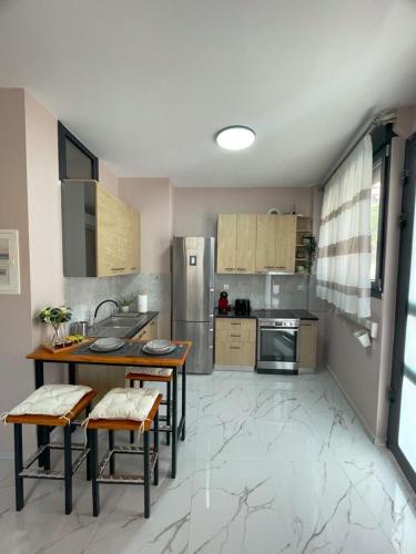 a kitchen with wooden tables and stainless steel appliances at Anastasia's Luxury House in Kavala