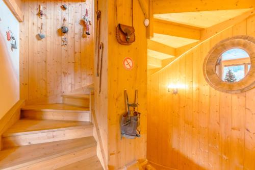 una escalera en una cabaña de madera con paredes de madera en superbe chalet Amitie jacuzzi proche lac et du centre avec reduction multipass ete, en Les Gets