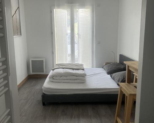 1 dormitorio con 1 cama con toallas en Room in Guest room - Home - Chambre independante a 10min Rer C et de Dourdan, en Sermaise