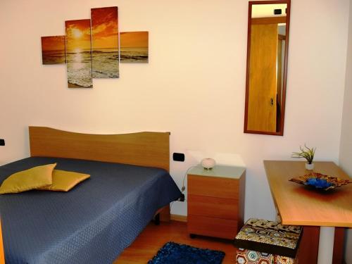 sypialnia z łóżkiem, stołem i lustrem w obiekcie Casa di Tony w Trapani