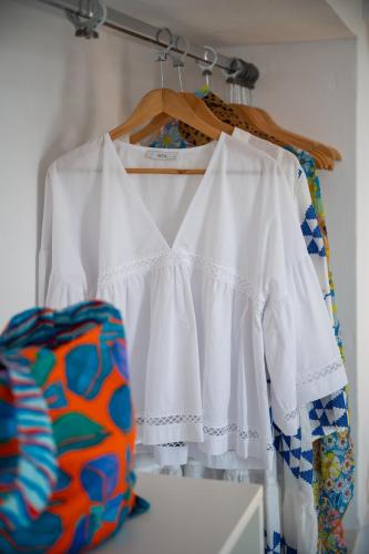 a pair of white shirts hanging on a rack at Kallichoron Art Boutique Hotel in Astypalaia Town