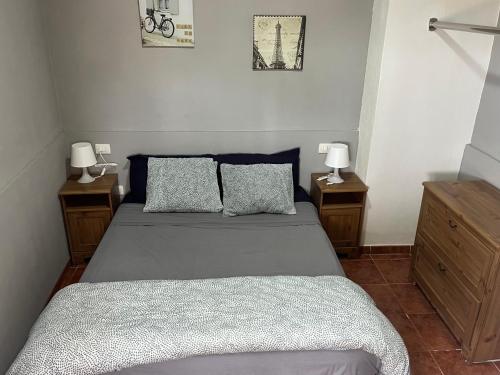 Un dormitorio con una cama con dos mesitas de noche y dos lámparas. en Casa Verde, en Vallehermoso