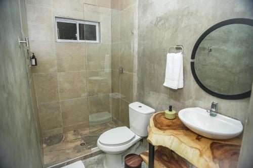 y baño con aseo, lavabo y ducha. en Bahía Boutique House, en Cartagena de Indias