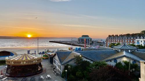een uitzicht op het strand en de oceaan bij zonsondergang bij Alexandra Hotel in Weymouth