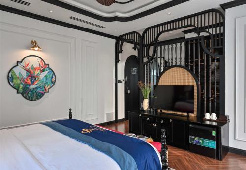 a bedroom with a black bed and a tv at Thiên Ân Boutique Hotel in Bạc Liêu