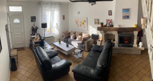uma sala de estar com um sofá e uma lareira em Jolie, cozy et confortable maison de ville au calme à 1h30 de Paris gare de l'est en train em Belleville-sur-Meuse