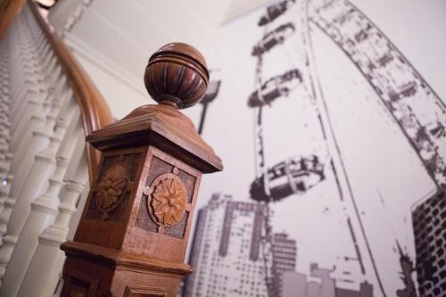 a clock tower with a ferris wheel in the background at Henley House Hotel in London