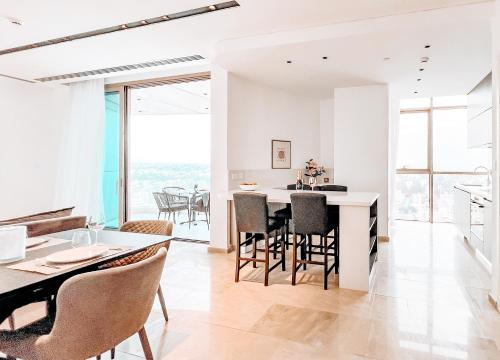 - une cuisine et une salle à manger avec des murs blancs et des baies vitrées dans l'établissement WealthyStays - Nicosia Heights, à Nicosie