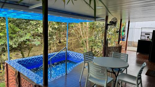 a porch with a table and chairs and a swimming pool at The Orchard Private Villa with Pool and Wifi in Cuenca Batangas in Cuenca
