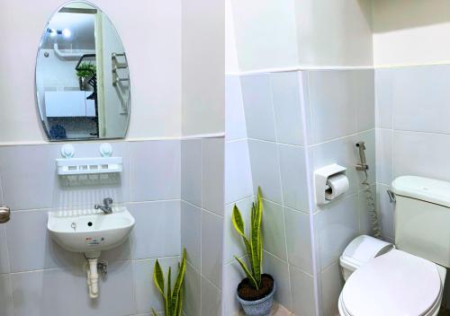 ein Badezimmer mit einem WC, einem Waschbecken und einem Spiegel in der Unterkunft Plumera Homes Nearest to Airport, Mall and School in Lapu Lapu City