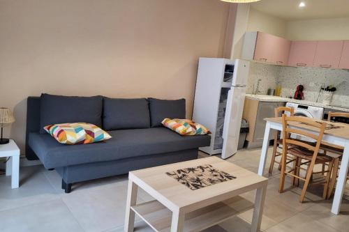 un salon avec un canapé bleu et une cuisine dans l'établissement Apartment with garden - sea view, à Palavas-les-Flots