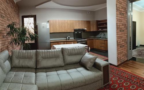 a living room with a couch and a kitchen at House4you in Tashkent