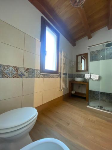 a bathroom with a toilet and a window at SUTTA L'ARCHI in Alia