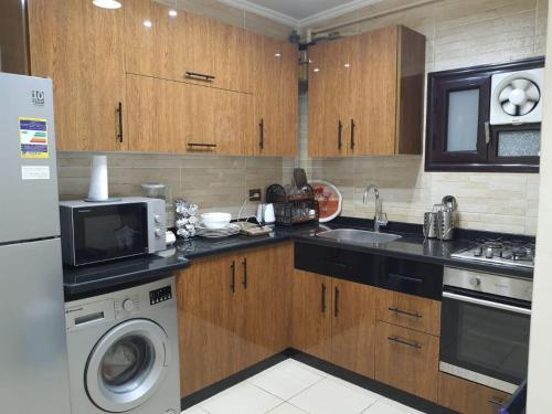 a kitchen with wooden cabinets and a washer and dryer at City Square in Alexandria