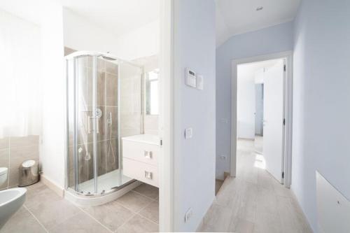 bagno bianco con doccia e lavandino di Home by Massi a Lido di Camaiore