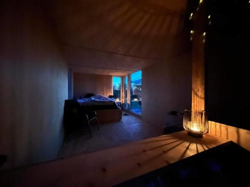 Habitación oscura con cama y lámpara. en Tiny summerhouse in Matsalu, 