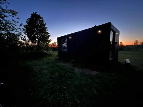 une petite maison assise dans un champ la nuit dans l'établissement Tiny summerhouse in Matsalu, 