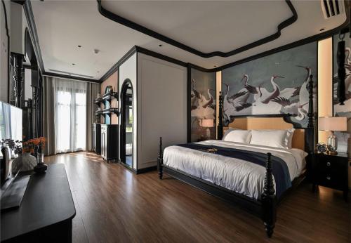a bedroom with a large bed with birds on the wall at Thiên Ân Boutique Hotel in Bạc Liêu