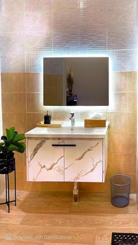 a bathroom with a sink and a mirror at استديو بأثاث انيق -النقرة in Hail