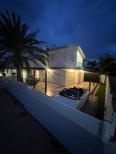 a white house with a boat in front of it at Villa Aleksandar in Protaras