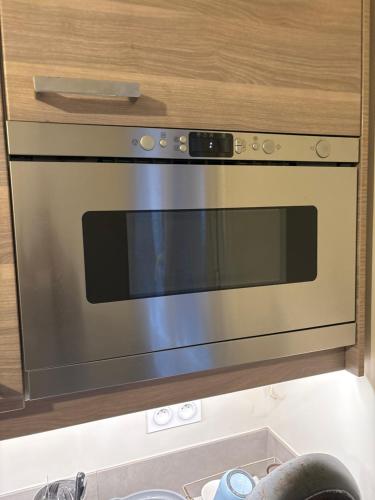 un four en acier inoxydable dans une cuisine dans l'établissement Pavillon Tawfik 1 à 4 personnes chez l’habitant, à Bagneux