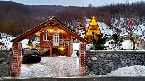 una casa en la nieve con un coche aparcado delante en Vilat Pllumaj, en Gropat e Selcës