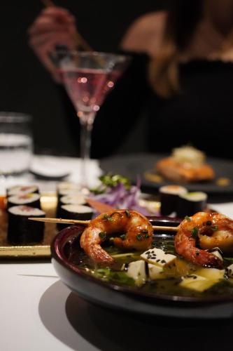 a plate of food with shrimp and a glass of wine at Steigenberger Icon Frankfurter Hof in Frankfurt/Main