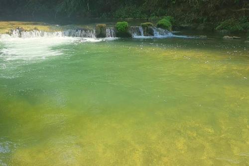uma piscina de água em frente a uma cascata em Sítio encantador com rio lindo em Bonito