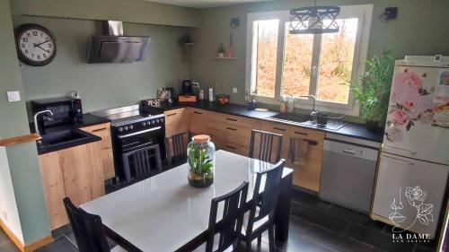 Il comprend une cuisine équipée d'une table blanche et d'un réfrigérateur. dans l'établissement La dame aux fleurs, à Lavaur