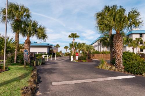 a street with palm trees and a building at Private Balcony - Beach - Pool and Pickleball in Tybee Island
