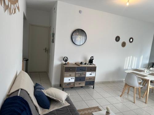 - un salon avec un canapé, une table et une commode dans l'établissement BLEU BLANC DUNES Appartement Plage Merlimont 10 mn Berck le Touquet, à Merlimont