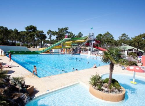 a large swimming pool with people in a water park at Mobil-home 6 personnes - Camping SIBLU Bonne Anse Plage in Les Mathes