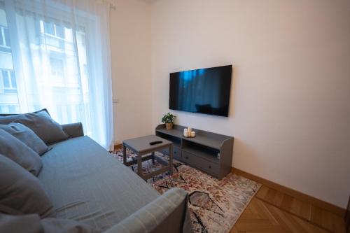 a living room with a couch and a flat screen tv at Festival's Home in Sanremo