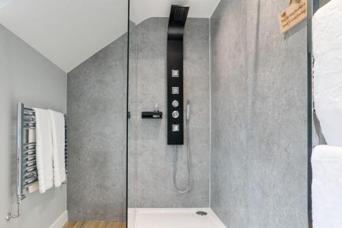 a shower with a glass door in a bathroom at Beam End Snainton - Modern 2-bedroom Stone Cottage in Snainton