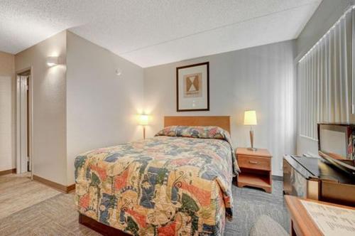 Habitación de hotel con cama y TV en Bridger Inn Hotel Downtown, en Las Vegas