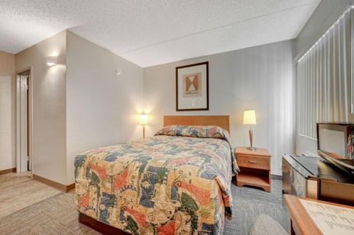 a hotel room with a bed and a television at Bridger Inn Hotel Downtown in Las Vegas