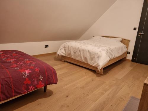 Schlafzimmer mit einem Bett und Holzboden in der Unterkunft La maison lumineuse in Hénin-Beaumont